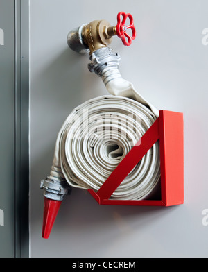 Feuerwehrschlauch an der Wand in einem modernen Gebäude Stockfoto