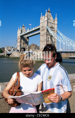 England, London, junge Tourist paar Blick auf London Karte vor der Tower Bridge Stockfoto