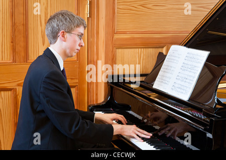 Junge Mann spielt einen Flügel Stockfoto