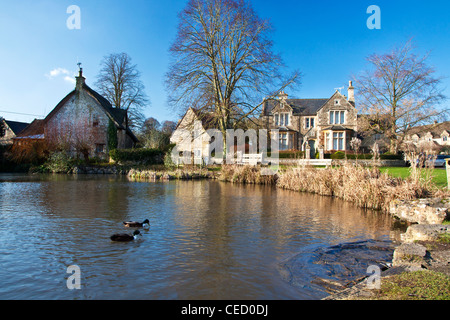 Häuser rund um ein typisch englisches Dorf Ententeich auf der grünen in Biddestone, Wiltshire, England, UK Stockfoto