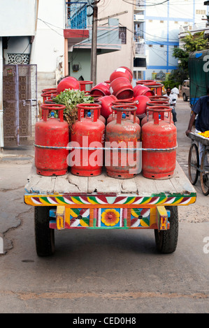 Indische Gas Flasche Lieferung auf einem Ochsenkarren in den Straßen von Puttaparthi, Andhra Pradesh, Indien Stockfoto