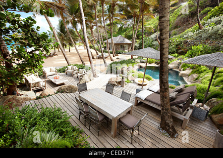 Strand Palmen Bäume Hängematte Cottage mit üppigen Pflanzen Stockfoto