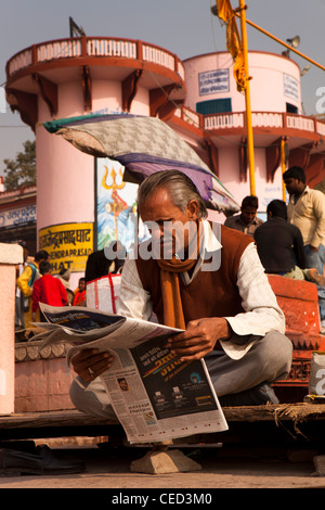 Indien, Uttar Pradesh, Varanasi, Prayag Ghat, Mann liest Zeitung im frühen Morgenlicht Stockfoto