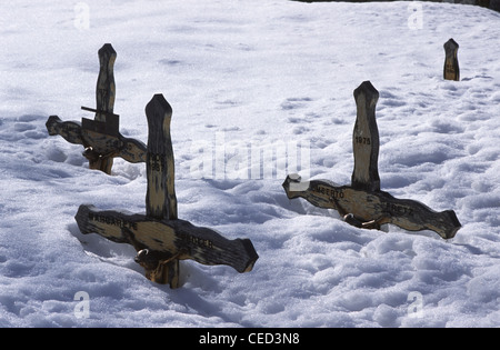 Hölzerne Grabkreuze decken sich im Tiefschnee auf dem Friedhof in Zermatt im Bezirk Visp im Kanton Wallis in den Schweizer Alpen. Stockfoto