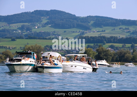 Horizontale Weitwinkelaufnahme mehrere Schnellboote verankert mit Menschen schwimmen und Sonnenbaden an einem sonnigen Tag. Stockfoto