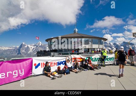 Horizontale Sicht auf das Schilthorn Aussichtsplattform mit müde Athleten laufen der Inferno Triathlon an einem sonnigen Tag. Stockfoto