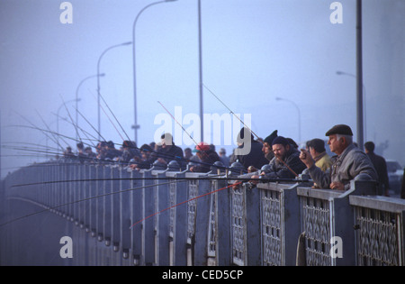 Leute Angeln mit Angelruten aus der Galata Brücke über das Goldene Horn in Istanbul Türkei Stockfoto