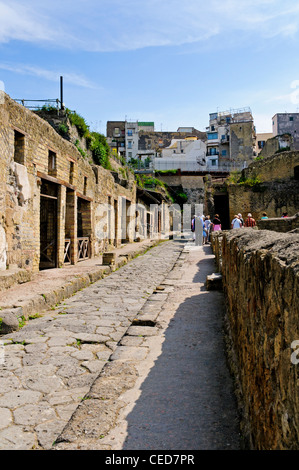 Touristen, die Eingabe der eleganten zweistöckigen Haus von Neptun und Amphitrite auf die Straße mit Kopfsteinpflaster von Cardo IV, Herculaneum Stockfoto