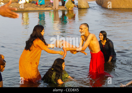 Aktivitäten am Tungabhadra Fluss in Hampi, Mutter und Vater ihres Sohnes im Fluss Tungabhadra, Hampi, Karnataka, Indien Baden Stockfoto