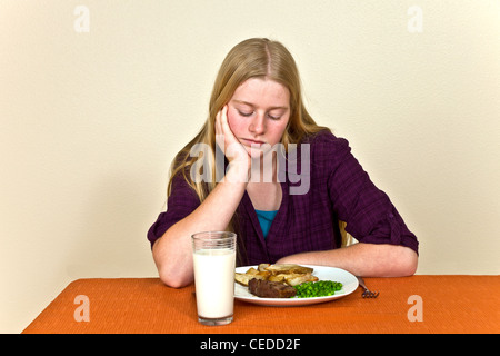 Willensstark hartnäckige unglücklichen Jungen Kaukasischen 14-15 Jahr alt Jugendmädchen am Tisch ungesunde Einstellung zum Essen Abneigungen Sitzen nicht © Myrleen Pearson Essen Stockfoto