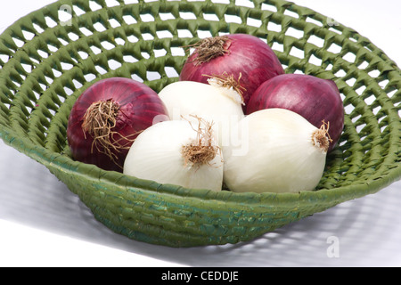 Weiße und rote Zwiebeln in einem Korb auf weißem Hintergrund Stockfoto