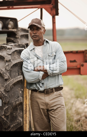 African American Farmer stehen in der Nähe von Traktor Stockfoto