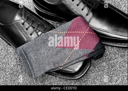 Ein paar Schuhe aus schwarzem Leder Kleid mit Argyle-Socken Stockfoto