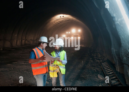 Bauarbeiter betrachten Blaupause im tunnel Stockfoto