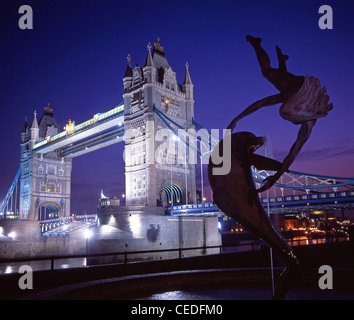 Tower Bridge und Delphin und ein Junge-Statue in der Abenddämmerung, Nordufer, London Borough of Tower Hamlets, London, England, Vereinigtes Königreich Stockfoto