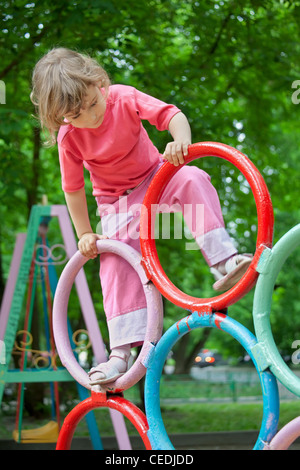 Das Mädchen spielt auf dem Kinderspielplatz Stockfoto