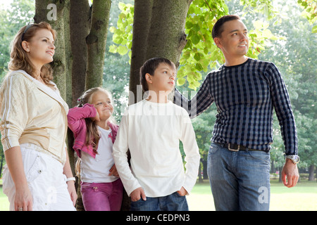 lächelnde glückliche Familie von vier suchen beiseite im freien Stockfoto