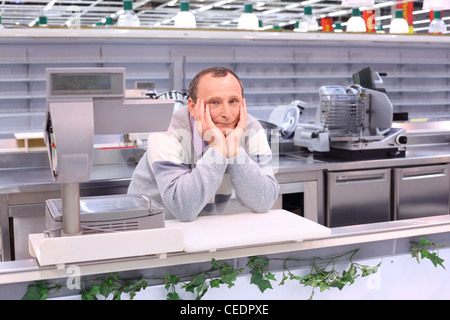 gelangweilte Verkäufer im Shop mit leeren Regalen und Theken Stockfoto