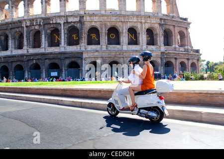 Paar reitet eine weißen Vespa an die römischen Kolosseum Rom Italien Stockfoto