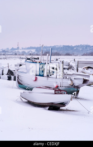 Angelboote/Fischerboote vertäut am Ufer des Flusses Rother Roggen Hafen East Sussex UK im Winter nach starken Schneefällen Stockfoto