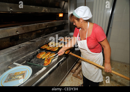 Italien, Basilicata, Roccanova, Bäckerei, Bäcker Calzoni aus dem Ofen nehmen, Calzone ist eine typisch italienische gefüllte Pizza Stockfoto