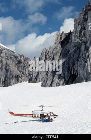 Wanderer Aussteigen aus einem Hubschrauber auf einem schneebedeckten Gletscher im Bereich von Bugaboo, Purcell Mountains in British Columbia, Kanada zu erkunden. Stockfoto