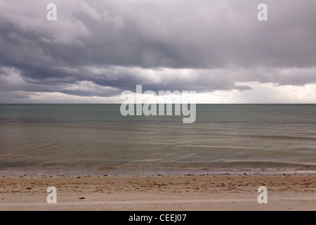 Schwere Gewitterwolken Verweilen über den gespenstisch ruhig Atlantik nach einem Hurrikan an einem Strand auf Key Biscayne, Florida. Stockfoto