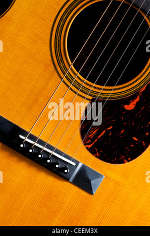 Detail einer Martin akustische Gitarre zeigt die Brücke, Streicher, Scratch Platte und Schallloch. Stockfoto