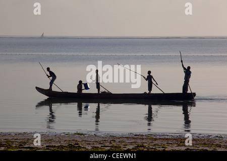 Lokalen Zanzibari Jungs gehen, Angeln, Bootfahren einer Dhau im Meer in Richtung Korallenriff in Bwejuu, Sansibar, Tansania Stockfoto