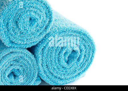 Blaue Handtücher auf weißem Hintergrund gerollt Stockfoto