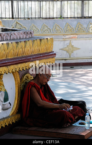 rote Roben buddhistischer Mönch zu meditieren, meditieren, beten beten Shwedagon Pagode Myanmar Burma Yangon Rangun historische Tempel heilige Stätte Stockfoto