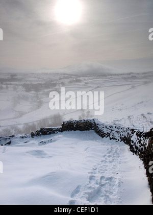 Malhamdale bei Nebel und Schnee von der Pennine Way Fußweg an der Spitze der Malham Cove, Yorkshire Dales National Park, North Yorks. Stockfoto