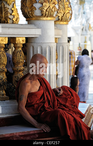 rote Roben buddhistischer Mönch zu meditieren, meditieren, beten beten Shwedagon Pagode Myanmar Burma Yangon Rangun historische Tempel heilige Stätte Stockfoto