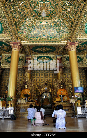 Gläubige beten beten Buddha anbeten buddhistischen Schrein Buddhismus Shwedagon Pagode Myanmar Burma Yangon Rangun Stockfoto