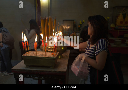 dh man Mo Temple SHEUNG WAN HONGKONG Chinesische Frau zündet Joss Stick Weihrauch Urnen taoistischer Tempel china Person brennende Kerze Stockfoto