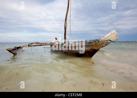 Zanzibari Dorfbewohner bringen seine Dhau in den Strand von Bwejuu, Sansibar, Tansania Stockfoto