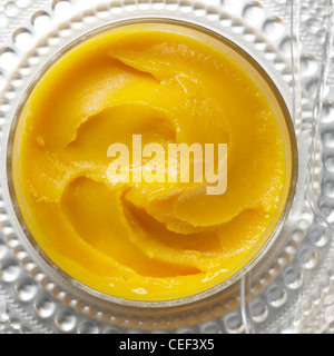 Sorbet Mango Wirbel rundes Glas Stockfoto