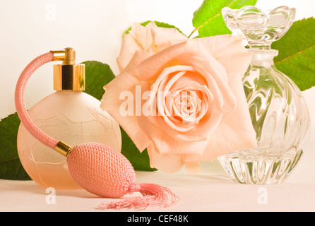 Weiche rosa Rose mit grünen Blättern und zwei kleine Flaschen Stockfoto