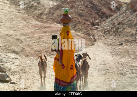Dorf Frau mit Baby und Last auf dem Kopf, Udaipur, Rajasthan, Indien Stockfoto