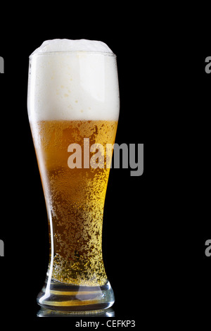 Glas Bier mit Schaum auf schwarzem Hintergrund Stockfoto