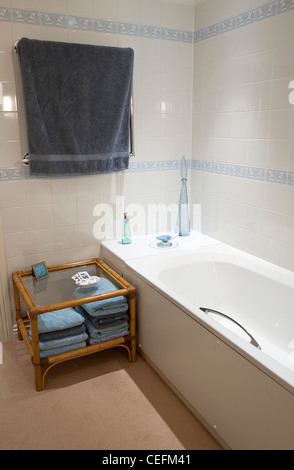 Badezimmer mit weißen Badewanne, moderne Einrichtung, geflieste Wände und Beistelltisch, Großbritannien Stockfoto