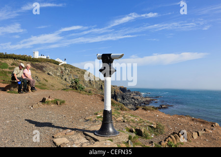 Öffentliche Teleskop und älteres Ehepaar auf Halbinsel Klippe kornischen Küste blicken. Lizard Point, Cornwall, England UK. Stockfoto