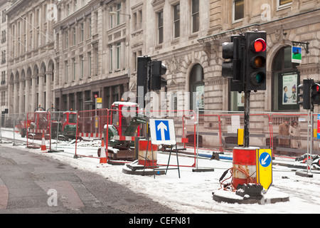 Rote Ampel und geschlossenen Lane auf Baustellen im Winter Schnee in der City of London, UK Stockfoto