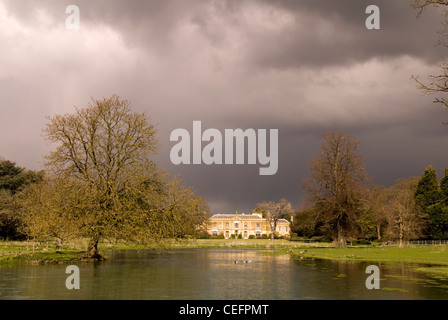 Great Missenden - Bucks - Missenden Abbey - gesehen über einen See - Sonnenlicht - Gewitterwolken nähert sich Stockfoto