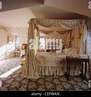 Opulentes floral Gardinen und Bettdecke auf Himmelbett im Land Schlafzimmer mit floral gemusterten Teppich Stockfoto