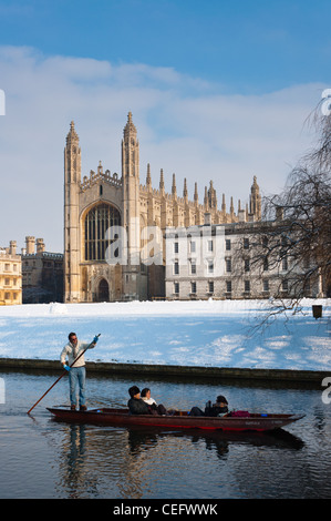Stochern am Ufer des Flusses Cam im Winter Schnee mit Kings College Chapel nach hinten. Cambridge, England.