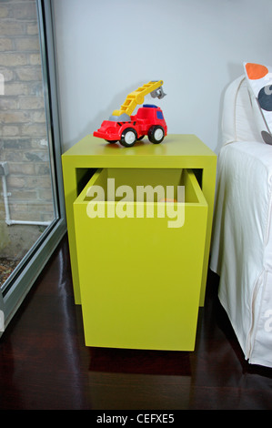 Nahaufnahme von roten Spielzeug LKW auf gelbe Tabelle mit großer Schublade in moderne Wohnzimmer Stockfoto