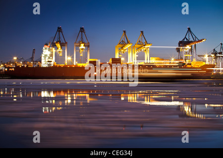 Langzeitbelichtung der Hamburg Süd Containerschiff im Hamburger Hafen.  Eis auf der Elbe zu sehen. Stockfoto