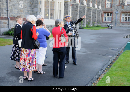 Eine Anleitung zeigt eine Gruppe von Besuchern rund um die berühmte öffentliche Schule, Christ es College in Christchurch, Neuseeland Stockfoto