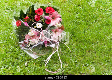 Bouquet von roten, rosa und weißen Blüten von Floristen Handauflegen Feld Gras Stockfoto